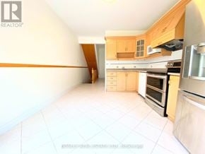Toronto (Little Portugal) townhouse for rent - A kitchen with white tiled floors and wooden cabinets.