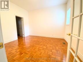 Toronto (Little Portugal) townhouse for rent - A room with wooden flooring and a doorway leading to another room.