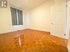 Toronto (Little Portugal) townhouse for rent - A room with a wooden floor and a white door.