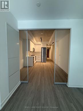 Toronto (Kensington-Chinatown) condo for rent - A hallway with a mirrored doorway leading to a kitchen.
