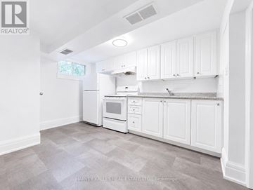 Toronto (Lawrence Park South) multi-family for rent - A kitchen with white cabinets and appliances in a real estate listing.