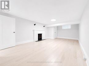 Toronto (Lawrence Park South) multi-family for rent - A spacious room with a fireplace and wooden flooring.
