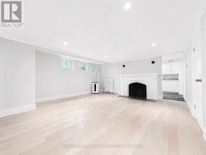 Toronto (Lawrence Park South) multi-family for rent - A spacious room with a fireplace and wooden flooring.