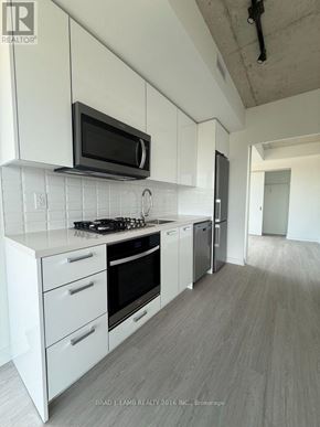 Toronto (Kensington-Chinatown) condo for rent - A modern kitchen with white cabinets and appliances.