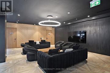 Toronto (Kensington-Chinatown) condo for rent - A modern living room with a black couch and a wooden floor.