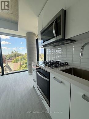 Toronto (Kensington-Chinatown) condo for rent - A modern kitchen with white cabinets and a black stove top.