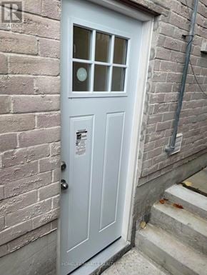 Ajax (Central East) apartment for rent - A grey door with a glass window is set in a brick wall.