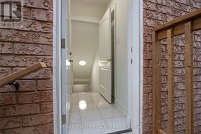 Mississauga (Churchill Meadows) apartment for rent - A hallway with a brick wall on the left and a wooden gate on the right.