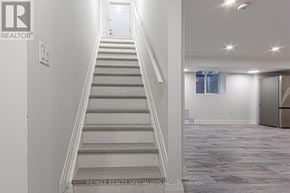 Mississauga (Churchill Meadows) apartment for rent - A staircase in a white room with a RE/MAX Realty Specialists Inc. logo on the wall.