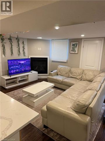 Kitchener apartment for rent - A living room with a white couch and a television.