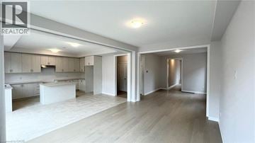 Cambridge apartment for rent - A spacious, empty room with a kitchen area in the background.