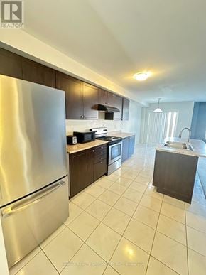Brantford townhouse for rent - A modern kitchen with a stainless steel refrigerator and a tiled floor.