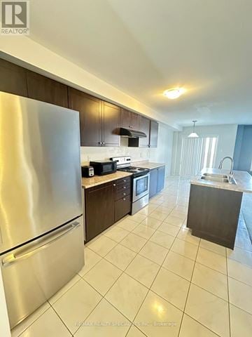 Brantford townhouse for rent - A modern kitchen with a stainless steel refrigerator and a tiled floor.