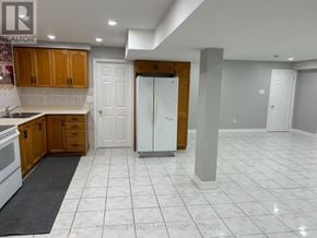 Toronto (West Hill) apartment for rent - A kitchen with white tile floors and wooden cabinets.