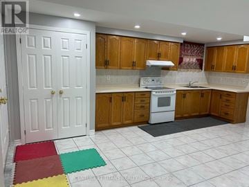 Toronto (West Hill) apartment for rent - A kitchen with wooden cabinets and a white stove top oven.
