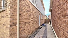 Brampton (Northwest Brampton) apartment for rent - A narrow alleyway between two brick buildings with a white pipe running down the center.