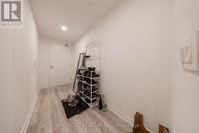Toronto (Kensington-Chinatown) condo for rent - A hallway with a shoe rack and a black mat on the floor.