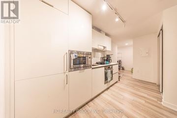 Toronto (Kensington-Chinatown) condo for rent - A kitchen with white cabinets and a refrigerator.