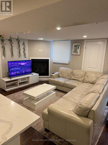 Kitchener apartment for rent - A living room with a white couch and a television.
