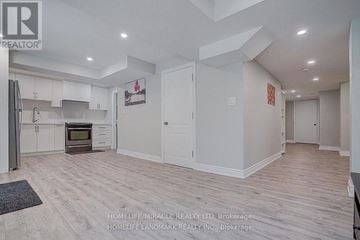 Ajax (Northeast Ajax) apartment for rent - A spacious kitchen with white cabinets and a wooden floor.