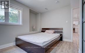 Ajax (Northeast Ajax) apartment for rent - A bedroom with a bed, a window, and a wooden floor.