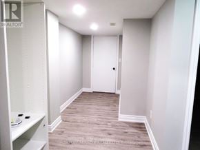 Ajax (Northeast Ajax) apartment for rent - A white hallway with a door and a shelf on the left.
