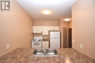 Brantford multi-family for rent - A kitchen with a sink and a refrigerator.