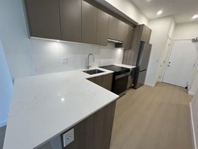Surrey apartment for rent - A kitchen with a white counter top and brown cabinets.