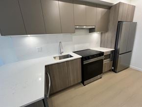 Surrey apartment for rent - A kitchen with a white counter top and stainless steel appliances.