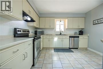 London apartment for rent - A kitchen with white cabinets and a black stove top oven.