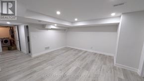Brampton (Bram West) apartment for rent - A spacious room with wooden flooring and white walls, with a doorway leading to another room.