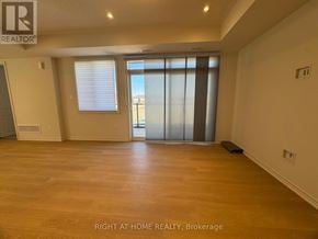 Kawartha Lakes (Lindsay) multi-family for rent - A spacious room with wooden flooring and a sliding glass door.