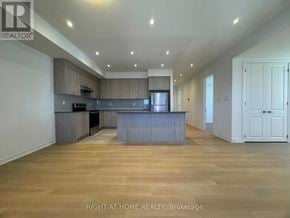 Kawartha Lakes (Lindsay) multi-family for rent - A spacious kitchen with wooden floors and a large island.