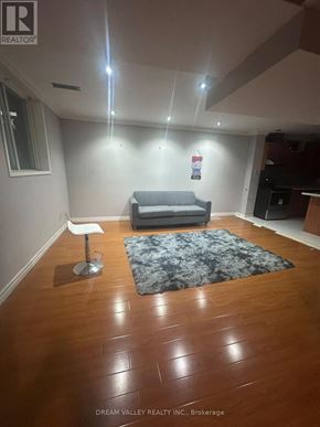 Pickering (Highbush) apartment for rent - A living room with a grey couch and a black and white rug.