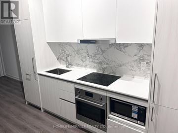 Vaughan (Vaughan Corporate Centre) condo for rent - A modern kitchen with white cabinets and a marble backsplash.