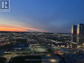 Vaughan (Vaughan Corporate Centre) condo for rent - A cityscape at dusk with a sign for HomeLife/Miracle Realty Ltd.