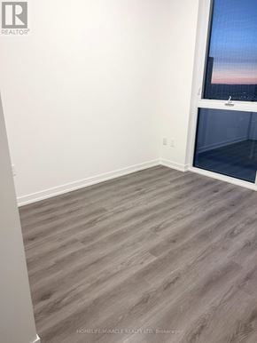 Vaughan (Vaughan Corporate Centre) condo for rent - A room with a window and wooden flooring.