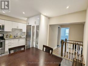 Toronto (Dovercourt-Wallace Emerson-Junction) apartment for rent - A kitchen with white cabinets and a wooden table.