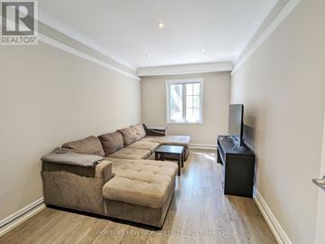 Toronto (Dovercourt-Wallace Emerson-Junction) apartment for rent - A living room with a large sectional sofa and a flat screen TV.