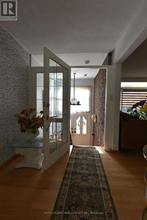 Toronto (Highland Creek) apartment for rent - A hallway with a rug on the floor and a chandelier hanging from the ceiling.