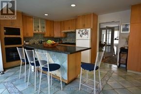 Toronto (Highland Creek) apartment for rent - A kitchen with a black granite countertop and blue chairs.