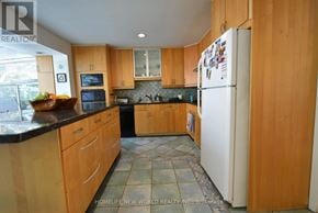 Toronto (Highland Creek) apartment for rent - A kitchen with wooden cabinets and a white refrigerator.