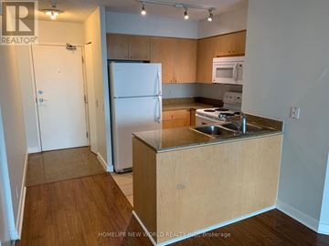 Toronto (Waterfront Communities) condo for rent - A kitchen with wooden cabinets and a white fridge.