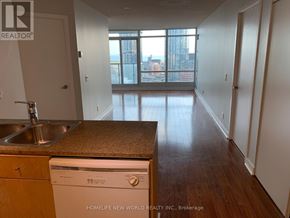 Toronto (Waterfront Communities) condo for rent - A kitchen with a sink, dishwasher, and wooden floors.