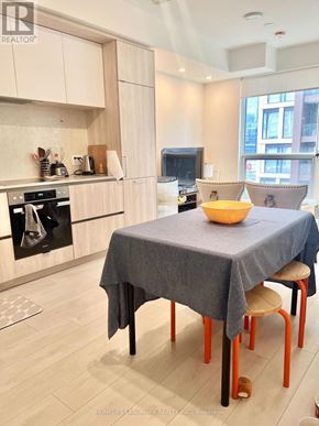 Toronto (Waterfront Communities) condo for rent - A kitchen with a table and chairs in front of it.