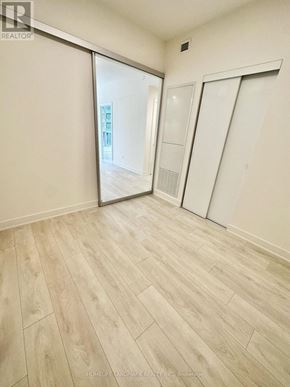 Toronto (Waterfront Communities) condo for rent - A room with a sliding door and wooden flooring.