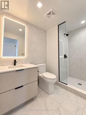 Toronto (North St. James Town) condo for rent - A white bathroom with a marble floor and a walk-in shower.