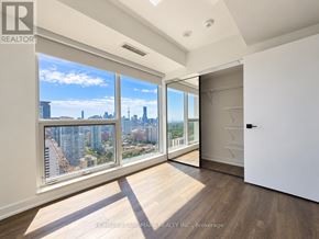 Toronto (North St. James Town) condo for rent - A well-lit, spacious room with a view of the city skyline.