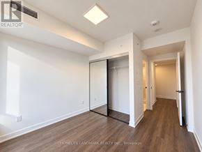 Toronto (North St. James Town) condo for rent - A room with a white wall and a wooden floor.