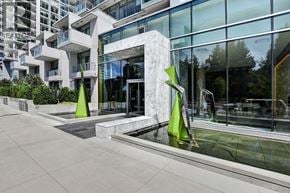 Burnaby apartment for rent - A modern building with a glass facade and a water feature in front.